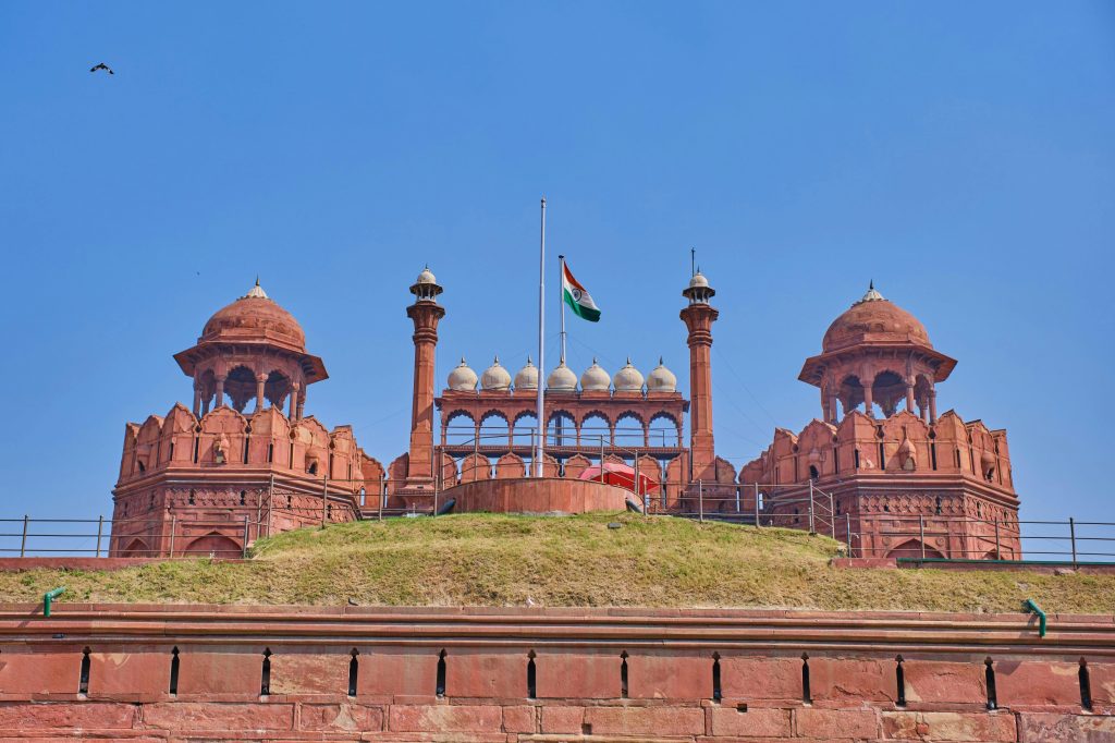Stunning view of the historic Red Fort in Delhi with Indian flag under clear blue sky.